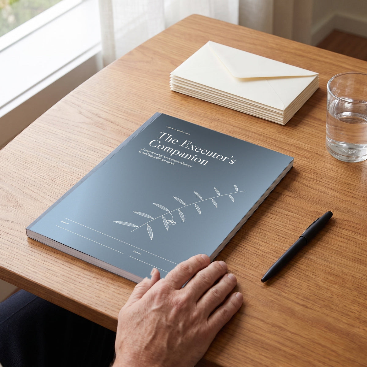 The Executor's Companion workbook on a desk beside envelopes and a pen