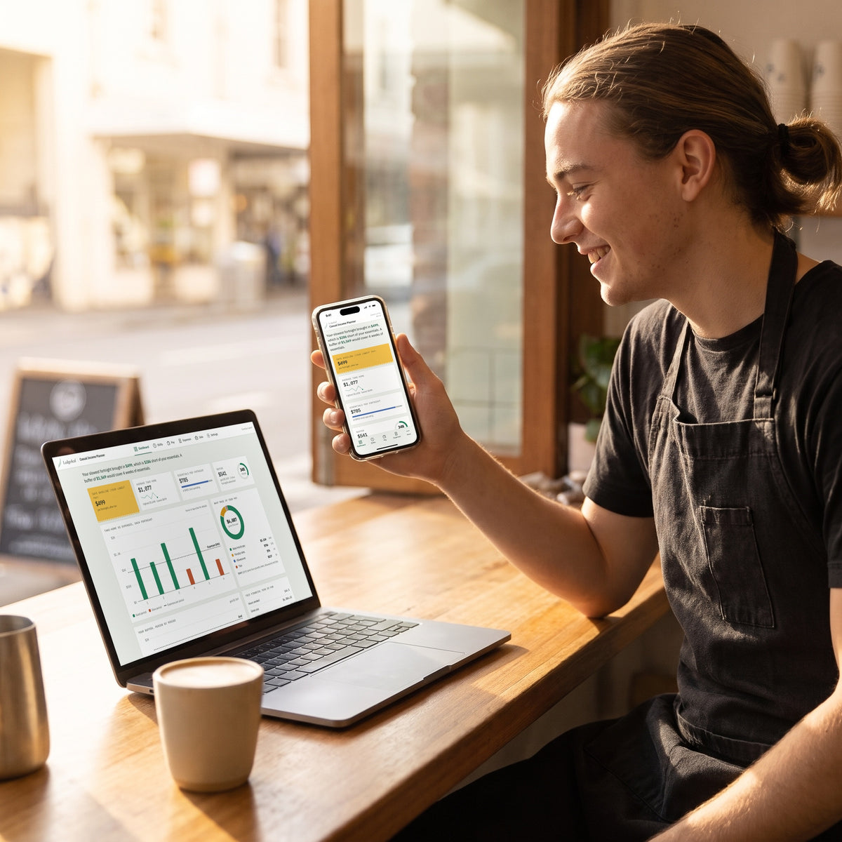 A barista on a break checking the Casual Income Planner on their phone and laptop in a sunny café