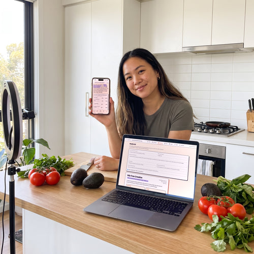 A food creator in her kitchen holding up her rate card, with the media kit open on a laptop